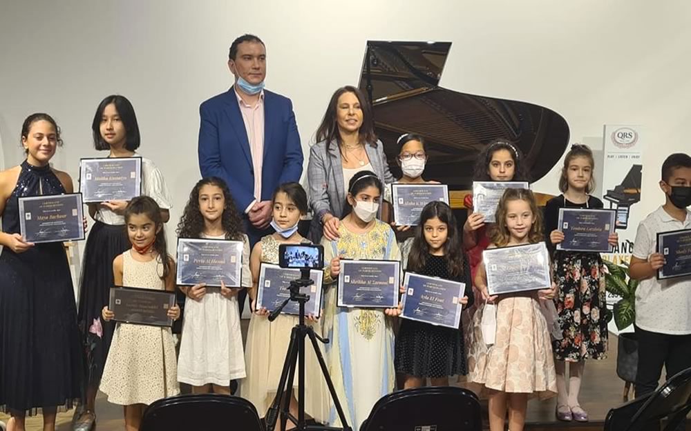 Marina Zamfir and Tofik Radjabov celebrate with student in a music course completion ceremony