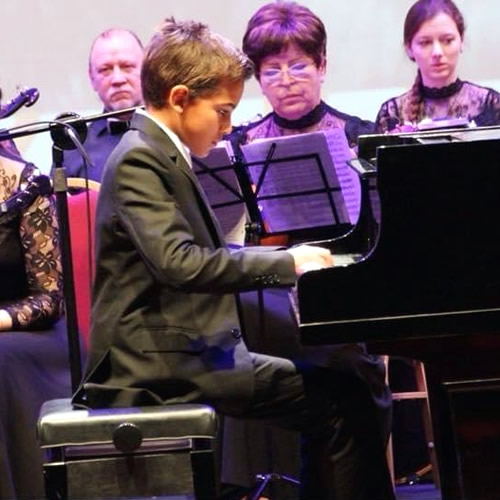 A student of Elite Music Institute playing piano on a live event
